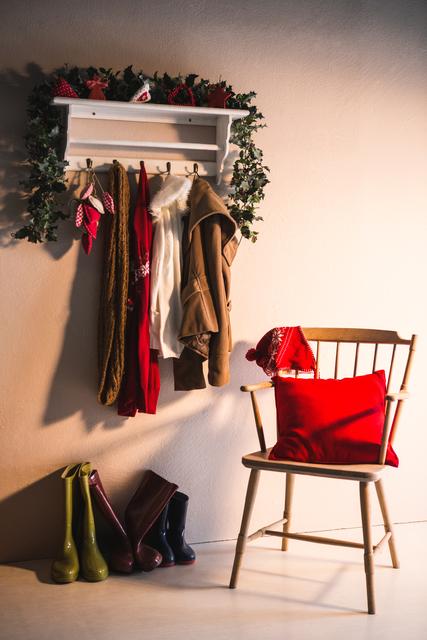 Winter clothes hanging on hook hanger and wooden chair at home