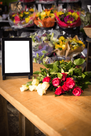 Transparent Tablet Display with Fresh Roses in Flower Shop