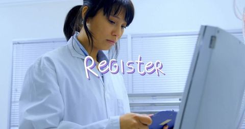 Asian lab technician entering data in scientific laboratory