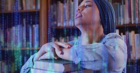 Student leaning on stacked books in library while digital code matrix streams across face