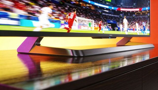 Sleek metal tv stand on glossy hardwood console showing live soccer with red #10 jersey