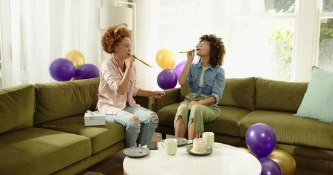 African American Friends Celebrating Birthday with Cake and Balloons on Green Sofa
