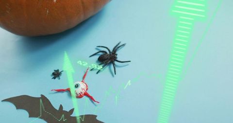 Augmented reality Halloween scene with toy eyeball, spider, pumpkin and green overlay