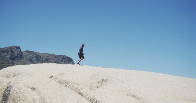 Man Hiking on Rocky Terrain with Clear Blue Sky - Download Free Stock Images Pikwizard.com