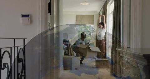 Young couple moving into home carrying boxes with globe overlay suggesting global move