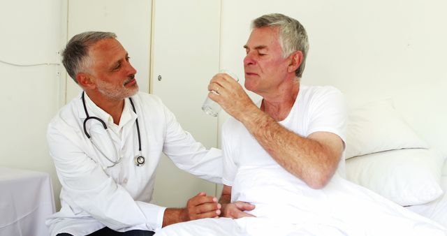 Doctor Assisting Elderly Patient Drinking Water in Hospital Room - Download Free Stock Images Pikwizard.com