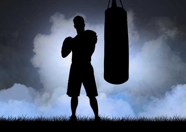 Digital composition of silhouette of boxer and punching bag against sky in background