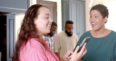Woman Showing Smartphone, Friend Surprised