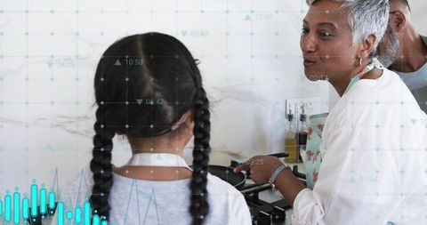 Grandparent teaching child cooking on kitchen stove while monitoring smart cooking data