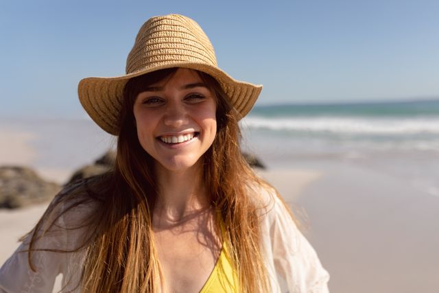 Beautiful woman in bikini and hat looking at camera on beach in the sunshine - Download Free Stock Photos Pikwizard.com