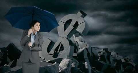 Businesswoman holding blue umbrella financial adversity