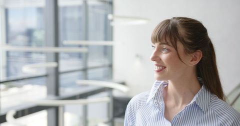 Business Woman in Striped Shirt Looking Out Office Window