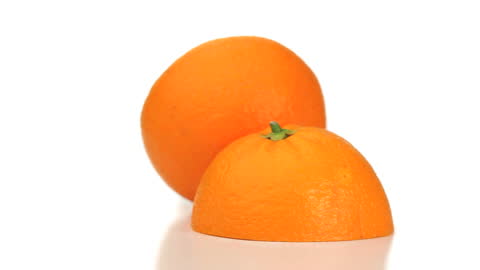Two Vibrant Orange Halves on White Surface