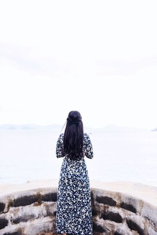 Woman with Long Hair Overlooking Sea in Floral Dress