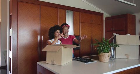 Diverse Female Couple Unpacking in New Home Kitchen