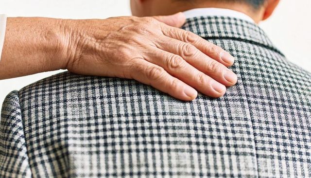 Placing senior hand on shoulder offering comfort support and quiet reassurance