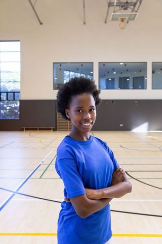 Confident Teenage Athlete in Gym Awaiting Basketball Practice