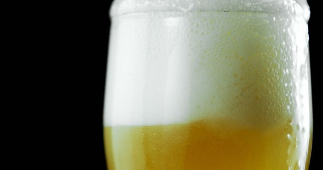 Close-Up of a Beer Glass with Frothy Head Against Black Background - Download Free Stock Images Pikwizard.com