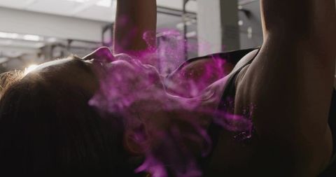 Female athlete performing chest press on flat bench with magenta powder burst backlit power