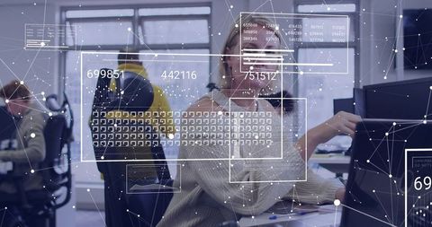 Mature professional analyzing data on monitor with augmented reality overlays in open office