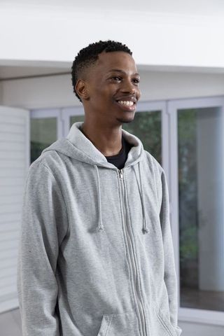 Smiling Man in Grey Hoodie Relaxing at Home