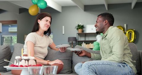 Multiracial Couple Celebrating Birthday with Cake at Home