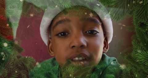 Festive African American Child Wearing Santa Hat Surrounded by Pine Boughs
