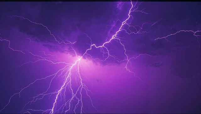 Vivid lightning bolt against dramatic purple sky