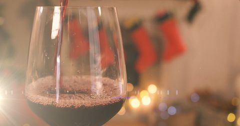 Red Wine Pouring in Holiday Ambiance with Christmas Decor