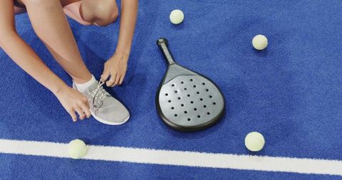 Preparing for a game of padel tennis on blue court