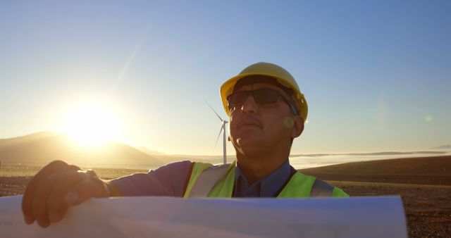 Engineer inspecting wind turbine with blueprint at sunrise - Download Free Stock Images Pikwizard.com