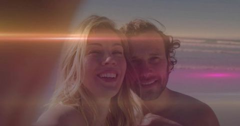 Smiling Couple Taking Selfie at Beach with Lens Flare