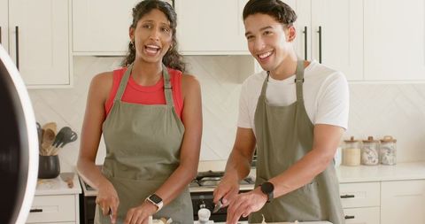 African american couple cooking together chopping onions on modern kitchen island