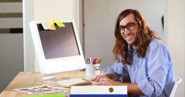 Young Professional with Long Hair Working at Modern Office Desk - Download Free Stock Images Pikwizard.com