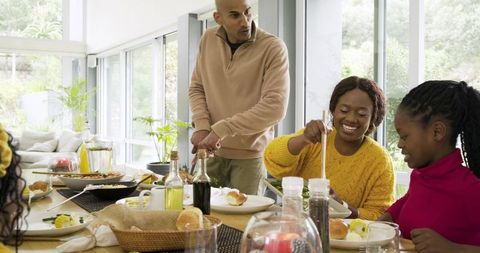 Multigenerational African American Family Sharing Sunlit Meal in Modern Dining Room