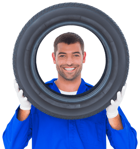 Smiling mechanic holding and looking through car tire transparent background