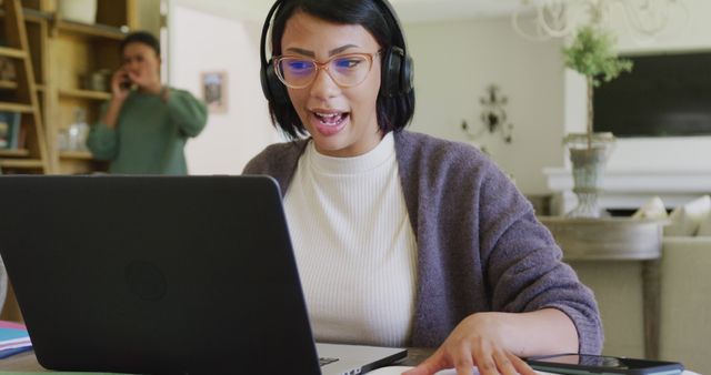 Young Woman Wearing Headphones Working Remotely on Laptop - Download Free Stock Images Pikwizard.com