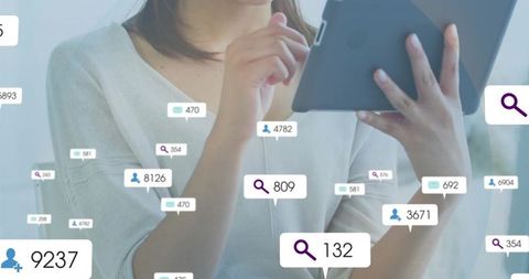 Woman Using Tablet Displaying Notifications in Modern Office Environment