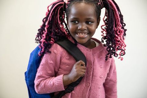 Joyful Child Wearing Pink Sweater with Braided Hairstyle