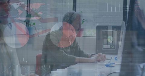 Man wearing headset analyzing data dashboards on desktop monitor in bright office