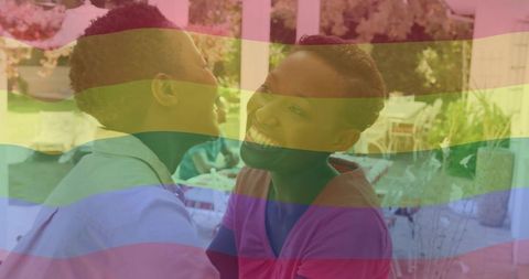 Laughing woman and child on porch with rainbow pride overlay, backyard family joy