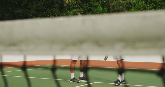 Tennis Players Chatting on Court Viewed Through Net - Download Free Stock Images Pikwizard.com