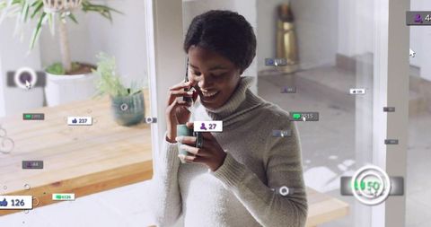 Woman talking on phone holding mug with social media overlays in bright minimalist home