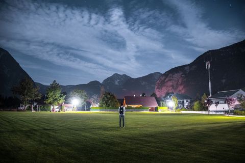 Lone Person Standing in Dark Field Under Starry Night Sky
