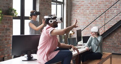 Professionals Engaging with Virtual Reality in Modern Office Environment