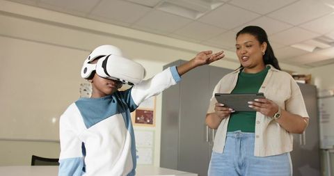 African American Teacher Guiding Teen Using VR Headset in Classroom for Immersive Learning