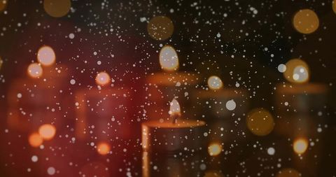 Falling snowflakes over festive candlelight ambiance