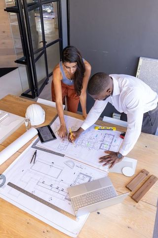 Architects Collaborating on Building Design Project with Blueprints