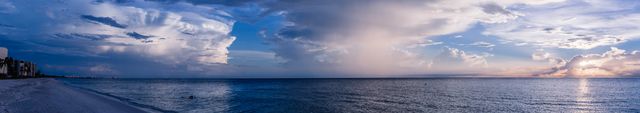 Scenic panoramic of serene beach at sunset with dramatic clouds offers a peaceful nature experience that suits travel, tourism promotion, nature blogs, and calming background themes in presentations and websites.