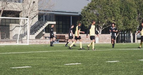 Amateur soccer match near goal on sunny field